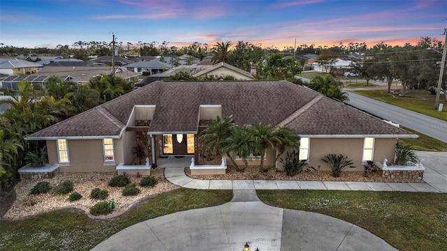 view of front of home featuring a residential view, stucco siding, and a shingled roof