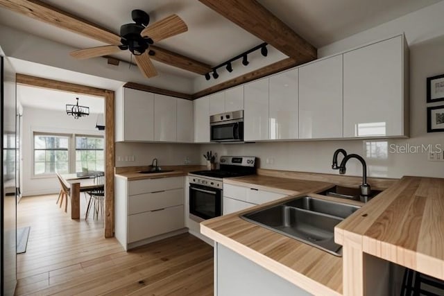 23309 Hartley Ave, Port Charlotte, FL 33954 - kitchen with wooden counters, a sink, beam ceiling, and stainless steel appliances
