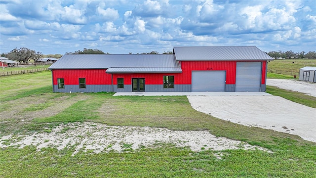 view of front of house with a front yard, an outbuilding, and a garage