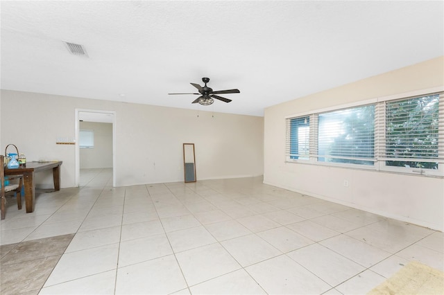 tiled empty room featuring ceiling fan