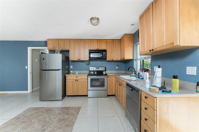 kitchen featuring sink, light tile patterned flooring, and stainless steel appliances