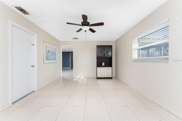 tiled empty room with ceiling fan