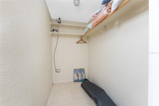 laundry room featuring washer hookup, light tile patterned floors, and a textured ceiling