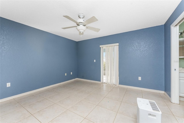 tiled spare room featuring ceiling fan