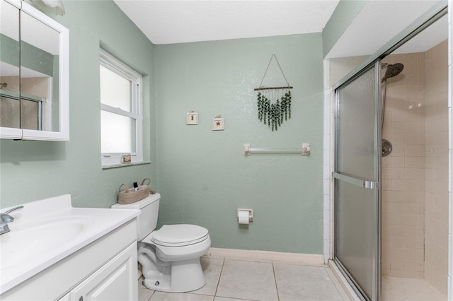 bathroom featuring vanity, tile patterned floors, toilet, a textured ceiling, and a shower with shower door