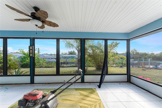 unfurnished sunroom featuring ceiling fan and a healthy amount of sunlight