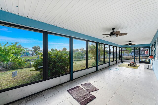 unfurnished sunroom with ceiling fan