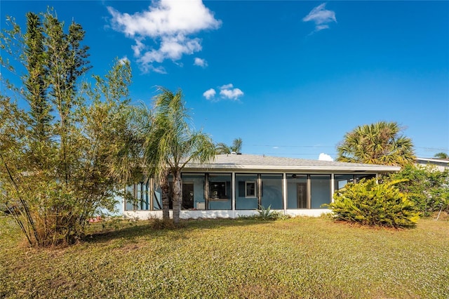 back of house with a lawn and a sunroom