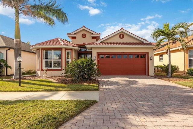 mediterranean / spanish house featuring a front yard and a garage