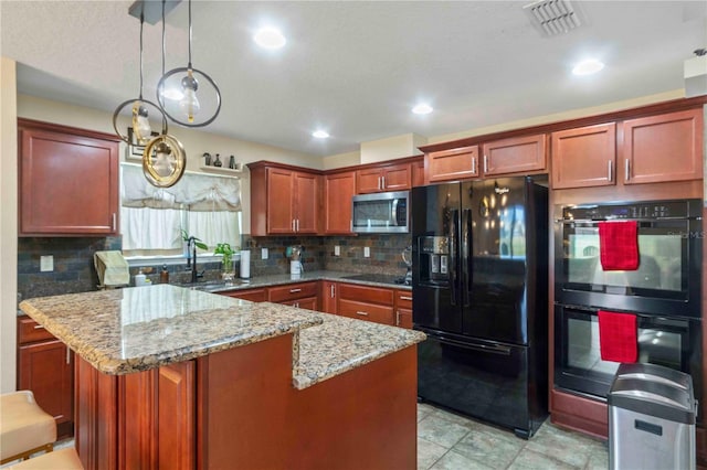 kitchen featuring pendant lighting, black appliances, sink, tasteful backsplash, and light stone counters