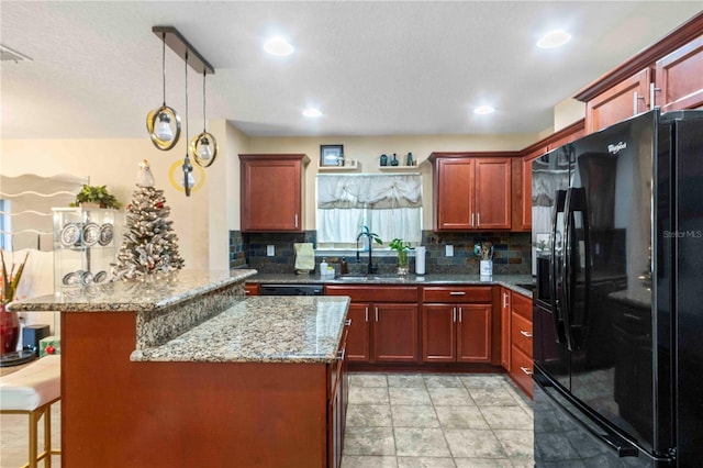 kitchen featuring sink, backsplash, a breakfast bar area, and black appliances