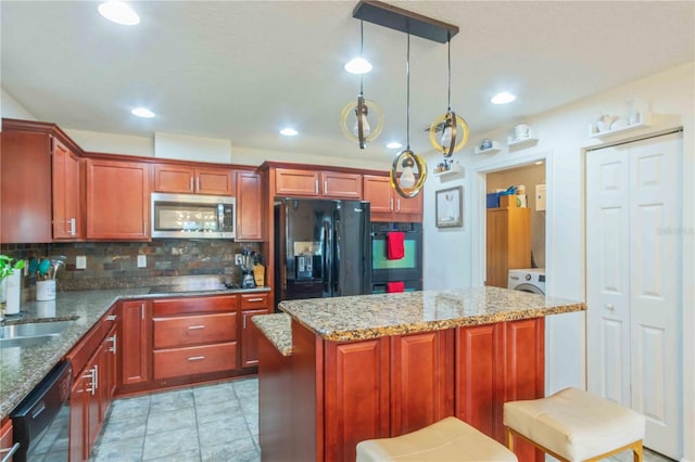 kitchen with stone counters, hanging light fixtures, a center island, and black appliances