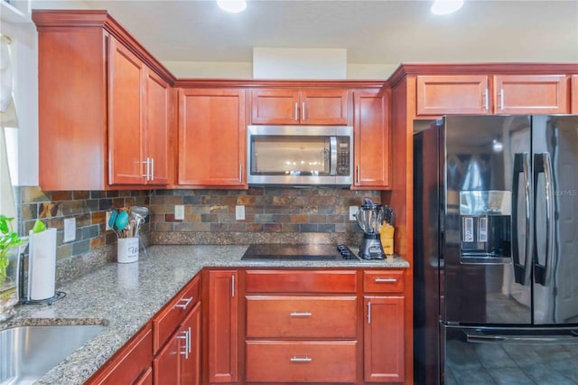 kitchen with black appliances, sink, light stone countertops, and backsplash