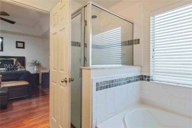 bathroom with shower with separate bathtub, hardwood / wood-style flooring, and ceiling fan