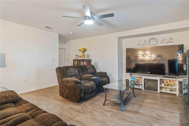 living room featuring ceiling fan, wood-type flooring, and lofted ceiling