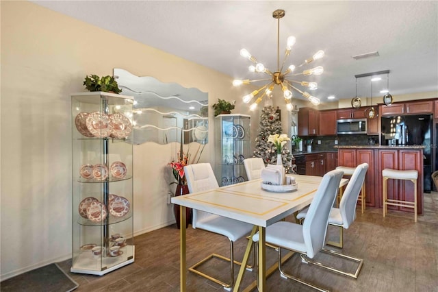 dining space with dark hardwood / wood-style flooring and an inviting chandelier