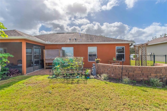 back of house with a lawn and a sunroom