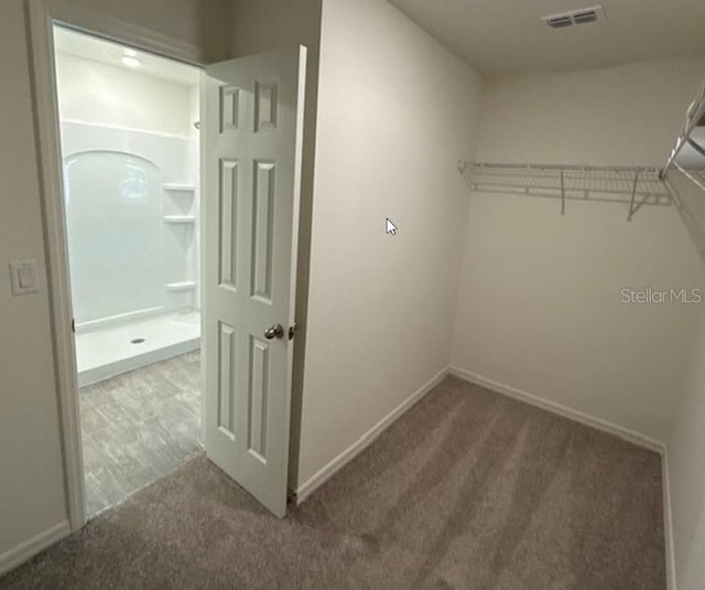 walk in closet featuring carpet flooring