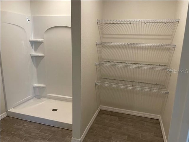 bathroom with hardwood / wood-style floors and a shower