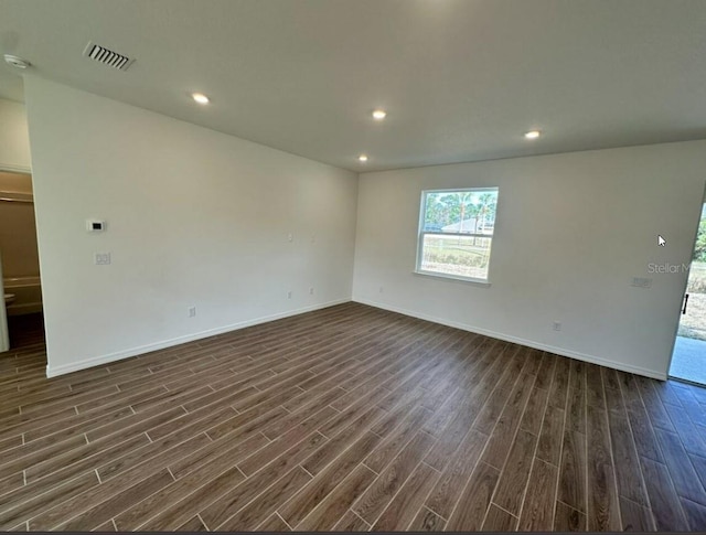 unfurnished room with baseboards, dark wood-type flooring, and recessed lighting