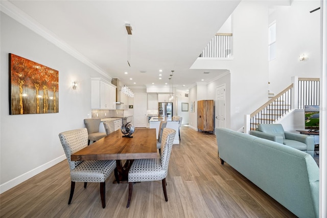 dining area featuring crown molding and light wood-type flooring