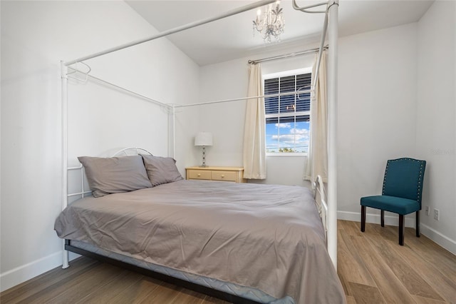 bedroom with wood-type flooring and a chandelier