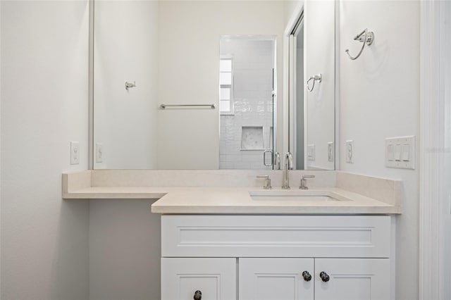 bathroom with a shower with door and vanity