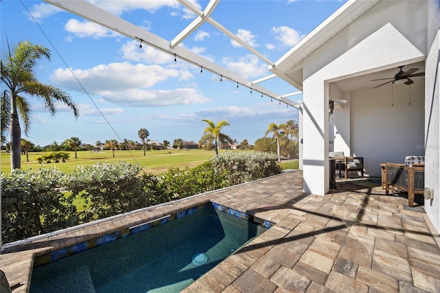 view of swimming pool featuring ceiling fan, a patio, and a jacuzzi