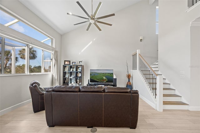 living room with light wood-type flooring, high vaulted ceiling, and ceiling fan