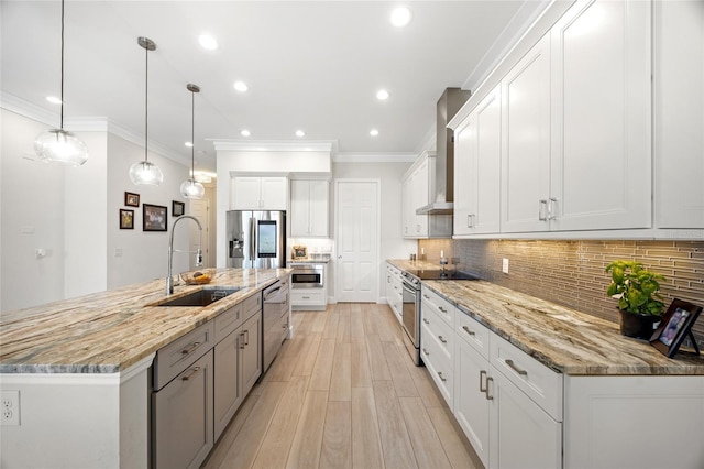 kitchen featuring wall chimney exhaust hood, sink, white cabinetry, and stainless steel appliances