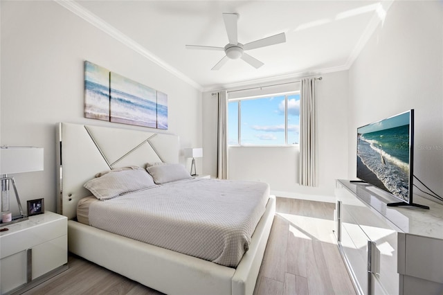 bedroom featuring ceiling fan, light hardwood / wood-style floors, and crown molding