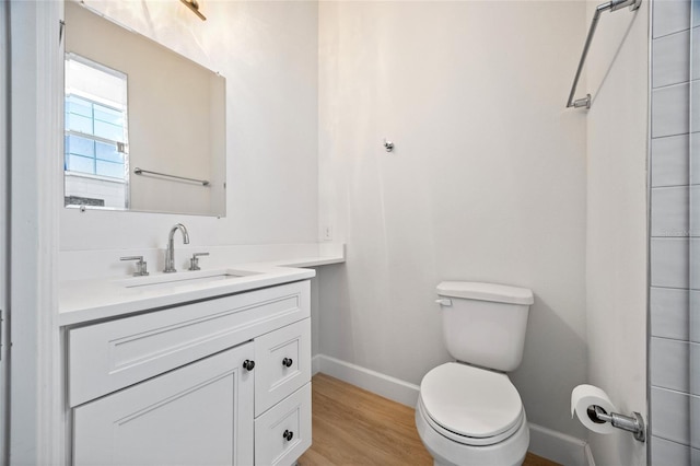 bathroom featuring vanity, wood-type flooring, and toilet