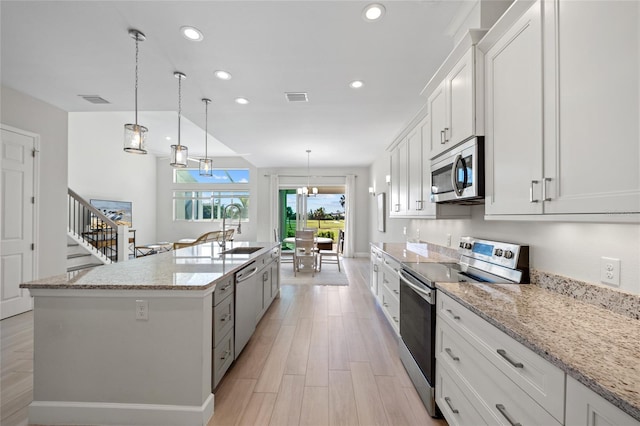 kitchen with a kitchen island with sink, sink, white cabinets, and stainless steel appliances