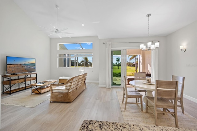 dining space featuring ceiling fan with notable chandelier and light hardwood / wood-style floors