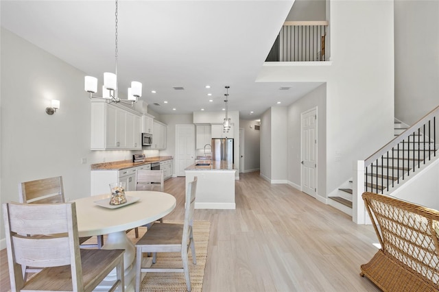 dining room featuring an inviting chandelier, light hardwood / wood-style flooring, and sink