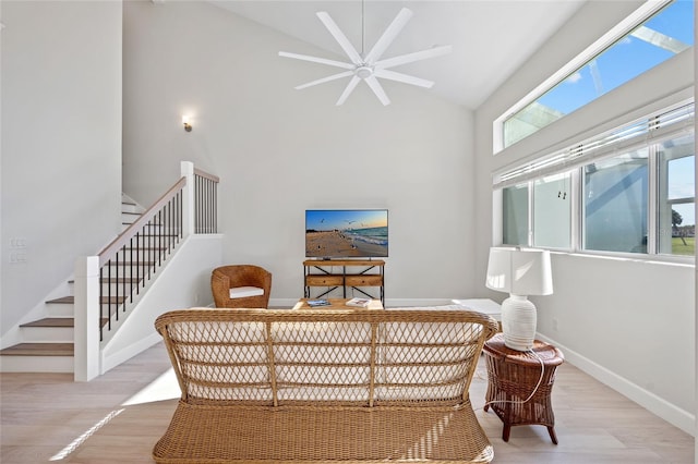 living area featuring ceiling fan, plenty of natural light, high vaulted ceiling, and light wood-type flooring