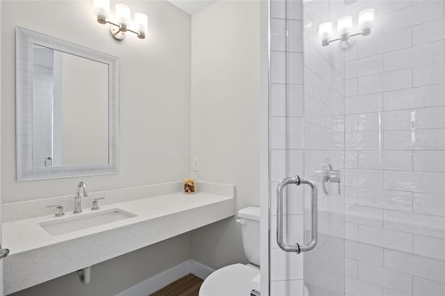 bathroom featuring wood-type flooring, toilet, an enclosed shower, and sink