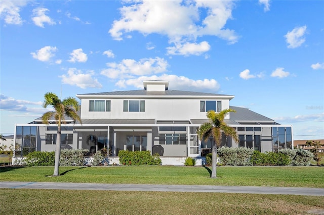 view of front of house with a lanai and a front lawn