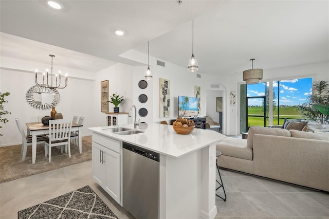 kitchen with stainless steel dishwasher, a kitchen island with sink, sink, white cabinetry, and hanging light fixtures