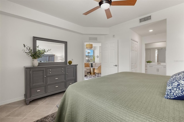 tiled bedroom featuring ensuite bath and ceiling fan