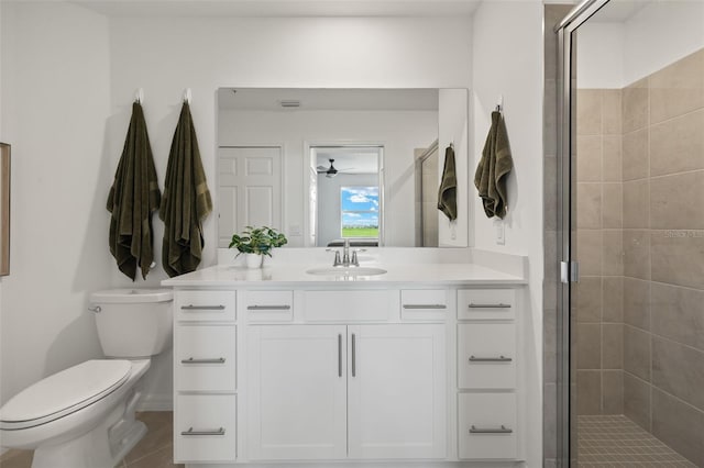 bathroom with ceiling fan, vanity, a shower with shower door, and toilet