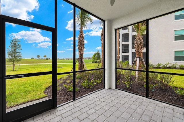 unfurnished sunroom featuring a ceiling fan