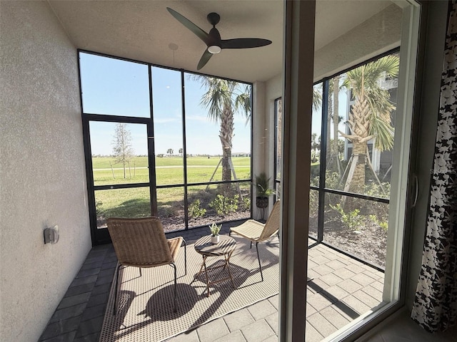 sunroom with plenty of natural light and a ceiling fan