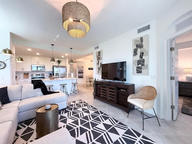 living room featuring a chandelier, recessed lighting, visible vents, and light tile patterned floors