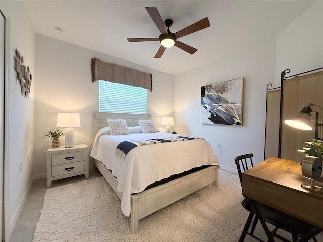 bedroom featuring light tile patterned floors, a ceiling fan, and baseboards