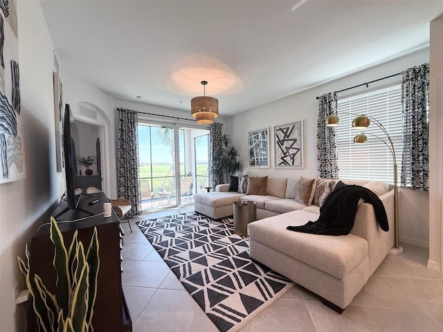 living area featuring light tile patterned floors and baseboards