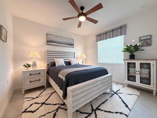 bedroom featuring light tile patterned floors, a ceiling fan, and baseboards