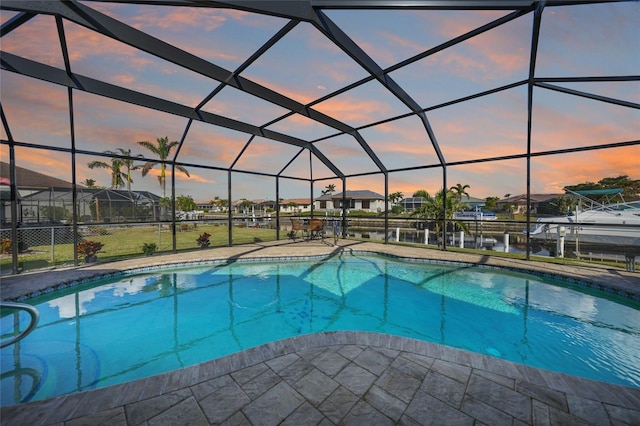 pool at dusk with glass enclosure and a water view