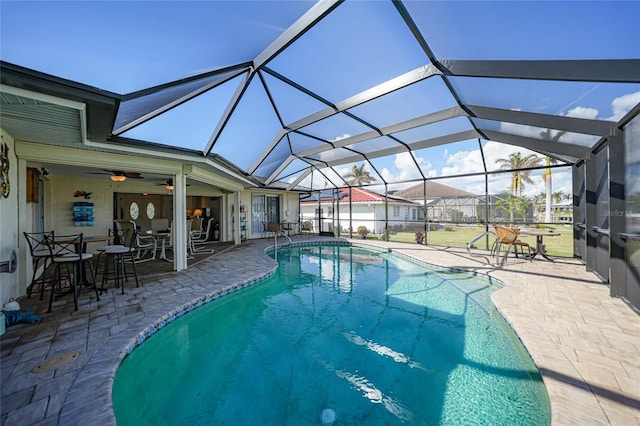 view of swimming pool featuring a bar, glass enclosure, and a patio area