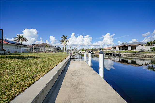 dock area with a water view and a lawn